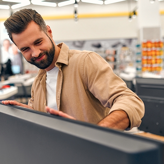 Mann beim Kauf eines Fernsehers.