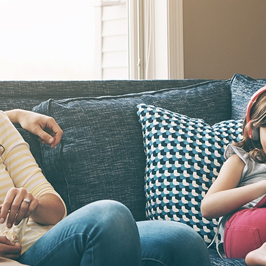 Eine Familie sitzt auf der Couch.
