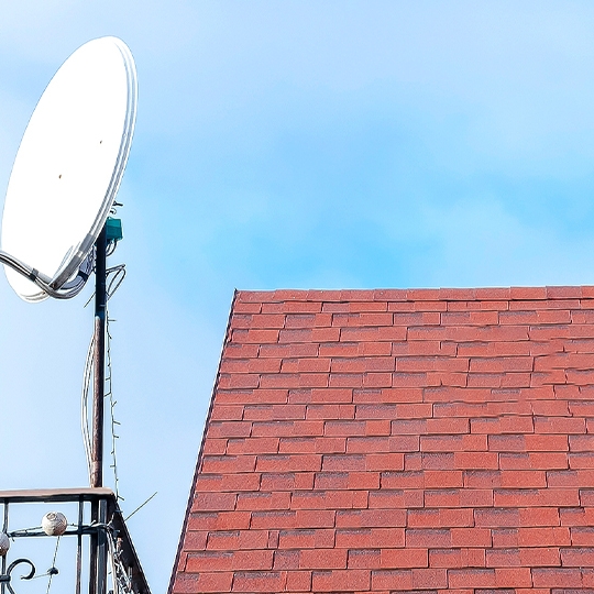 Das Dach eines Hauses mit einer Satellitenschüssel.