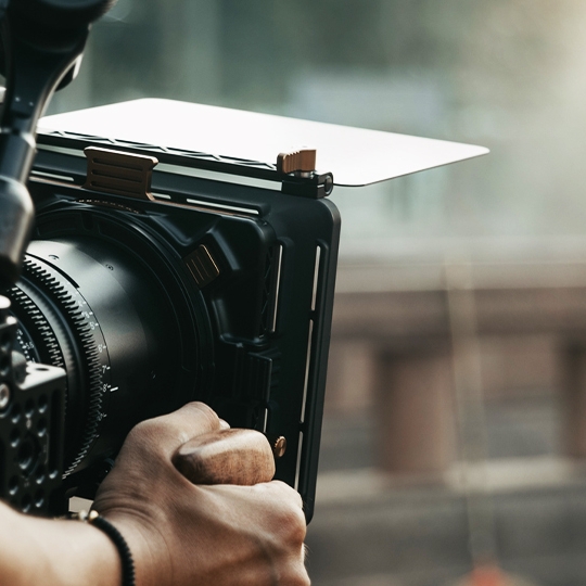 Eine Person filmt eine andere Person mit einer Filmkamera.