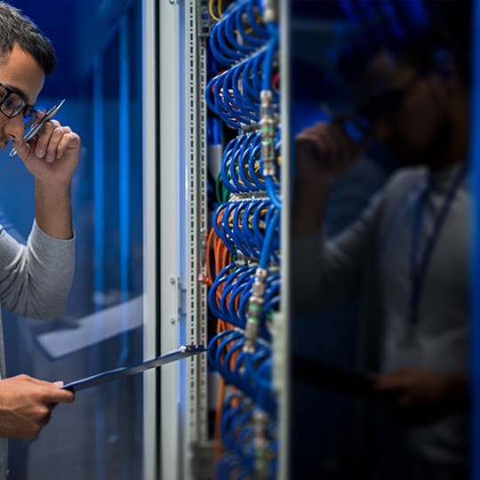 Techniker konzentriert mit vielen Kabeln