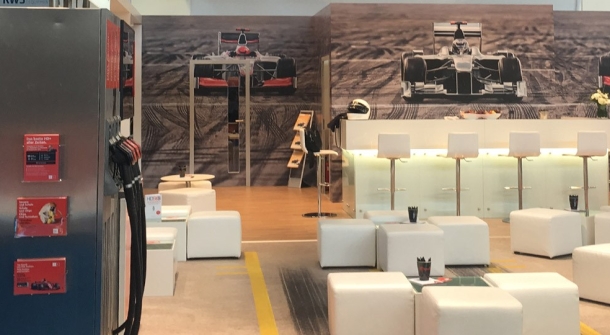 Messestand von ASTRA mit Werbeslogan für Ultra HD über Satellit und einem Formel-1-Boxenstopp-Motiv im Hintergrund