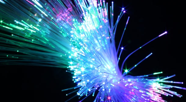 Nahaufnahme von Glasfaserkabel, die bunt leuchten.