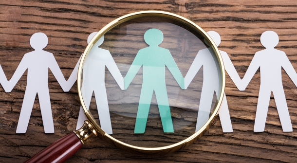 Geschnittenes Papier, das so aussieht, als würden Menschen Hand in Hand stehen.